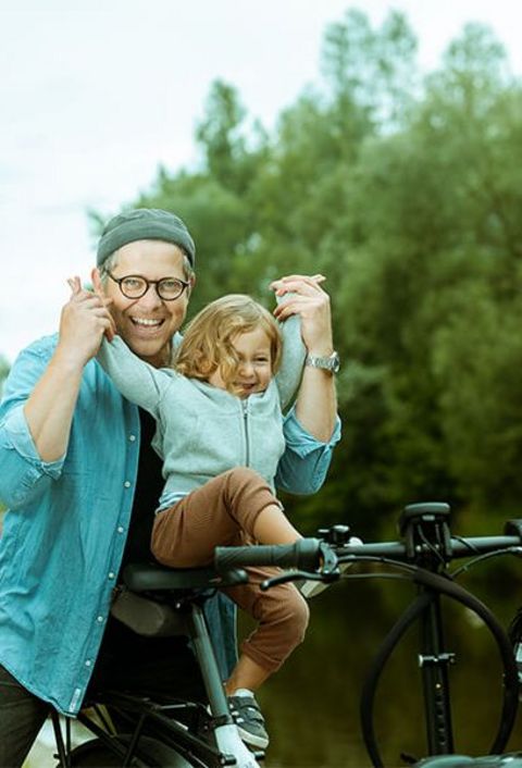 Ein Vater und seine kleine Tochter machen einen Fahrradausflug in der Natur und haben dabei viel Spaß.